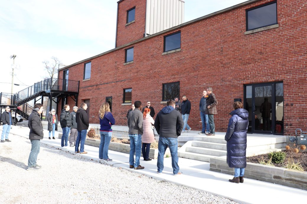 people standing in front of a brick building