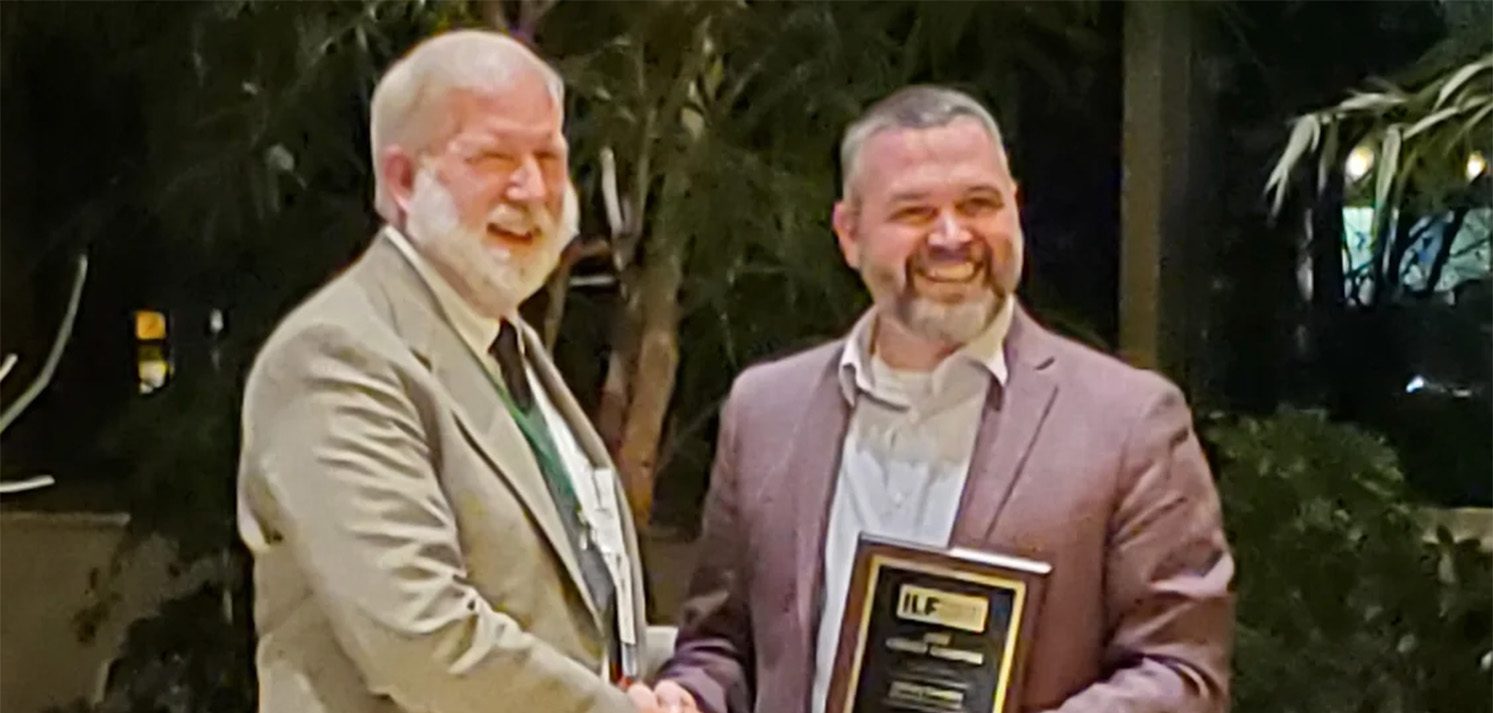 Michael Williams and Zachary Benedict holding ILF award