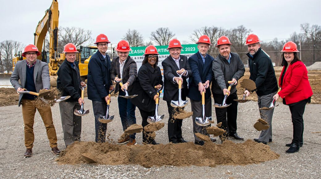 Village Premier Ground breaking with people wearing red hard hats