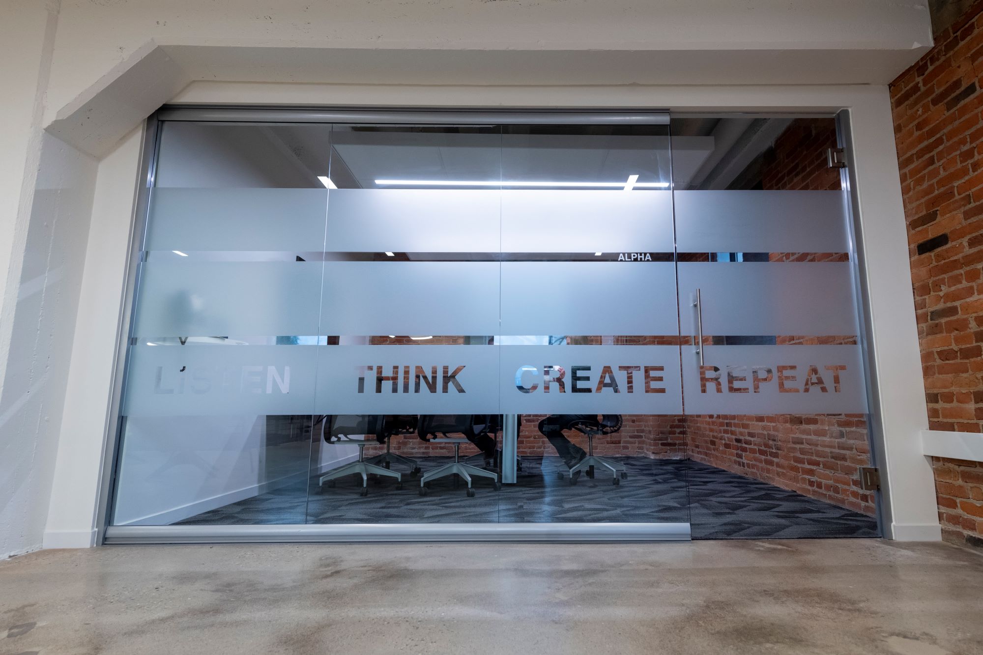 MKM architecture + design private meeting room that says listen, think, create, repeat, on glass