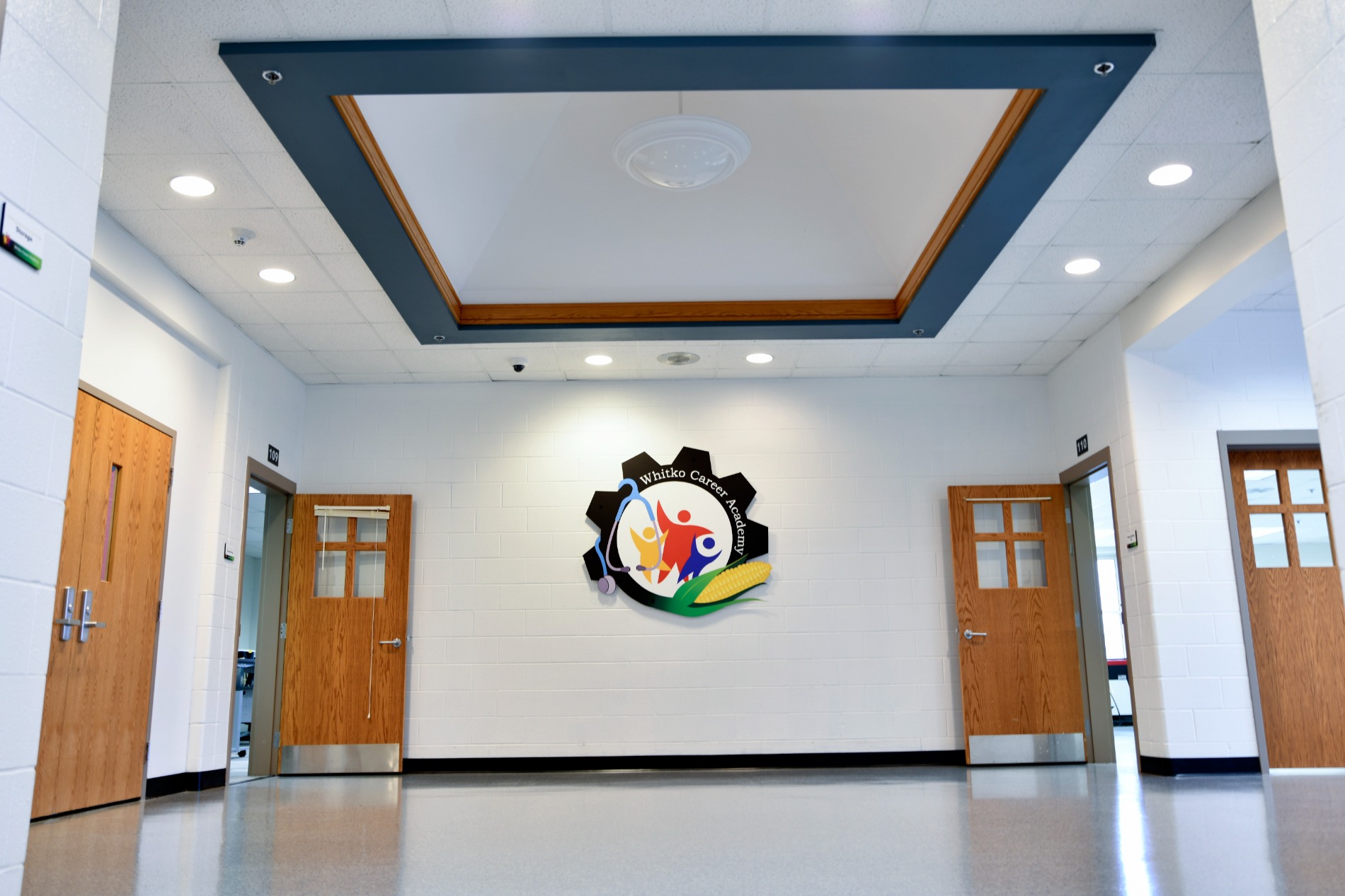 Whitko Career Academy hallway featuring gear-shaped logo and wood doors