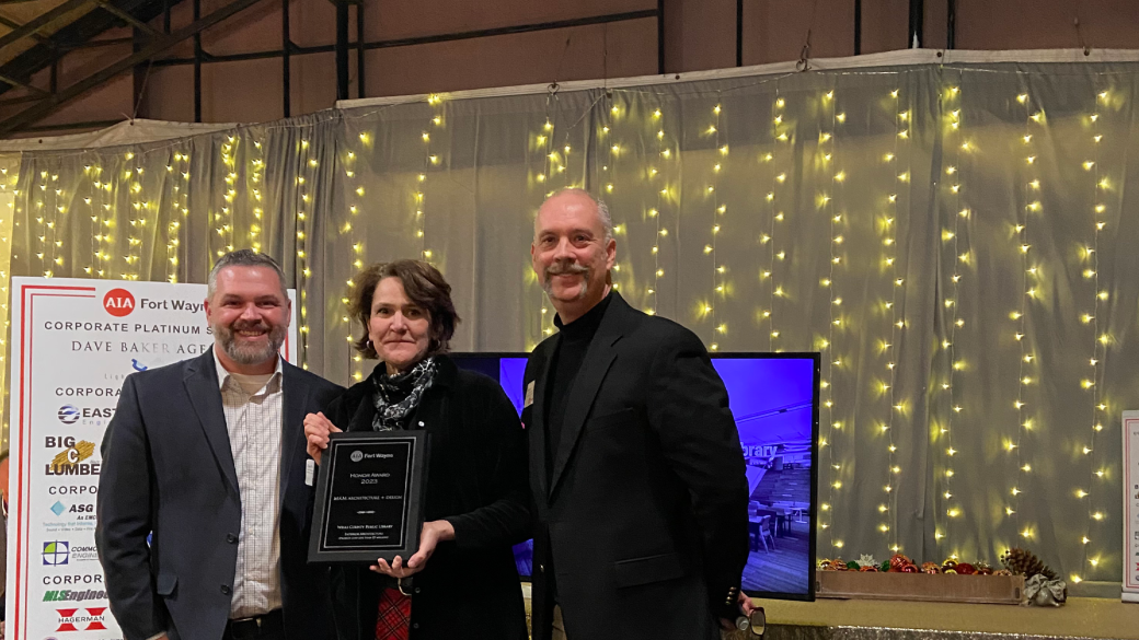 three people posing with an award