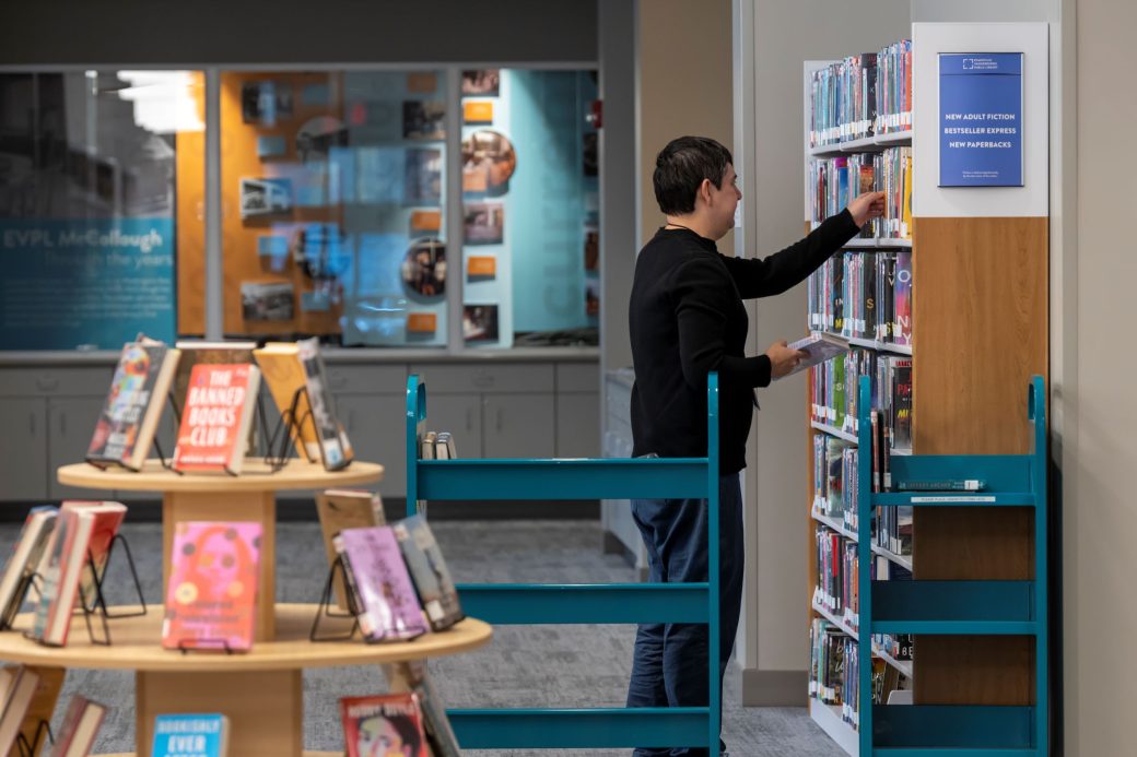 man stocking library shelves