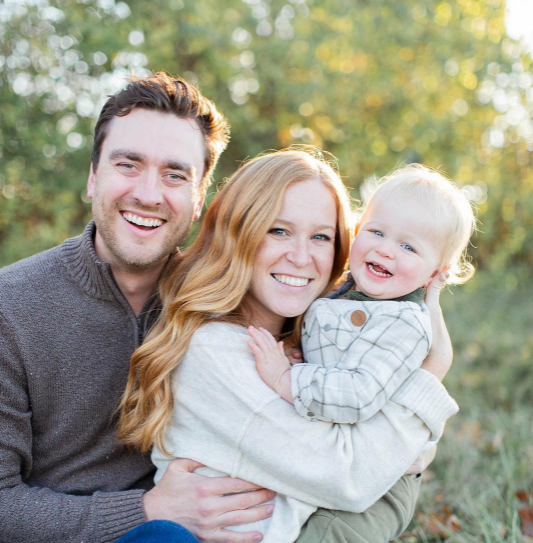 man woman and baby smiling