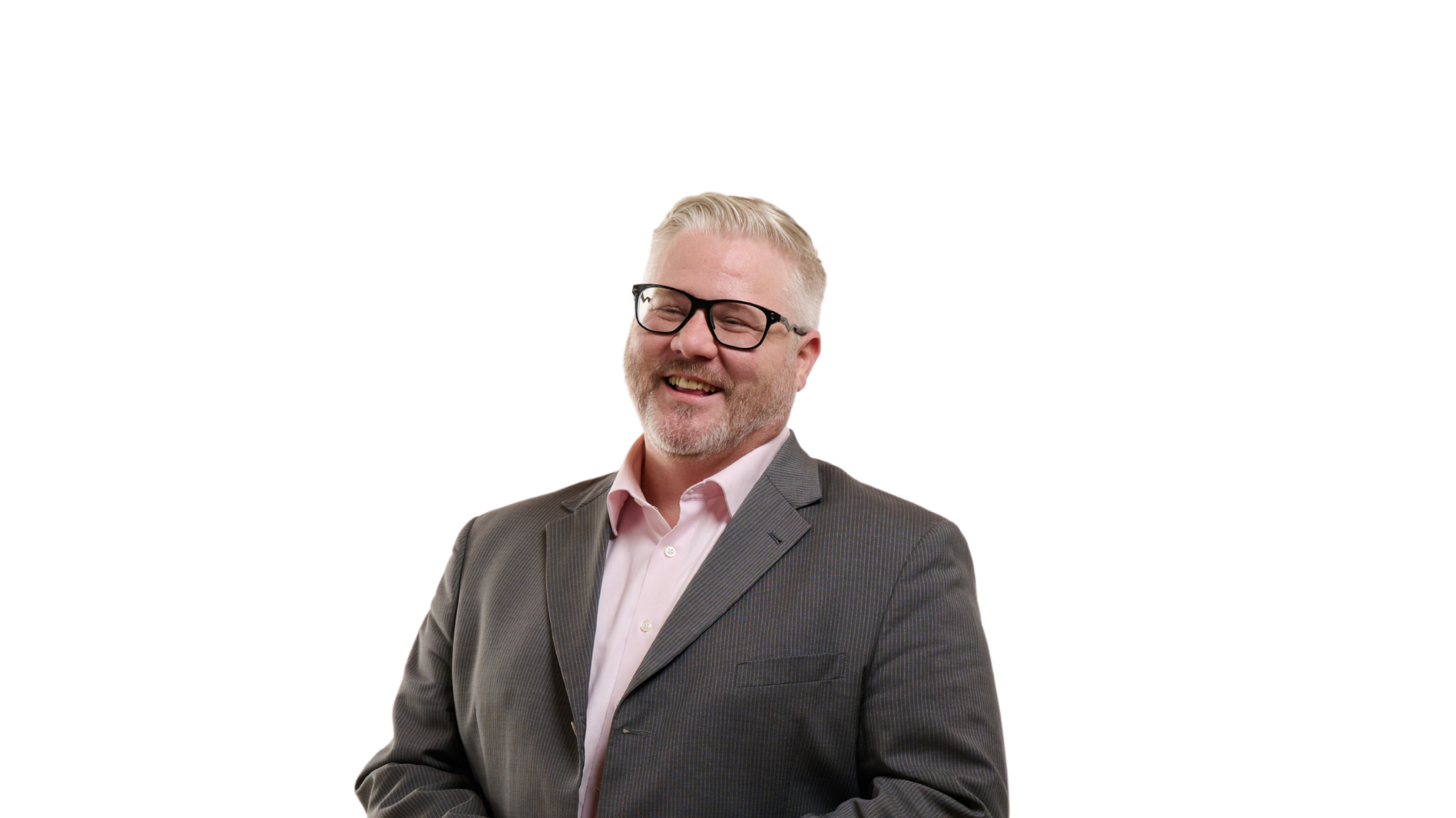 Man with gray hair, moustache, and beard, smiling and wearing glasses, pink button down shirt with collar, gray blazer